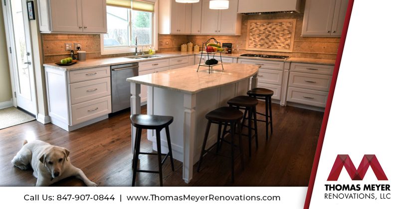 Dog Laying on Hardwood Kitchen Floor Next to Kitchen Island with Seating - Thomas Meyer Renovations
